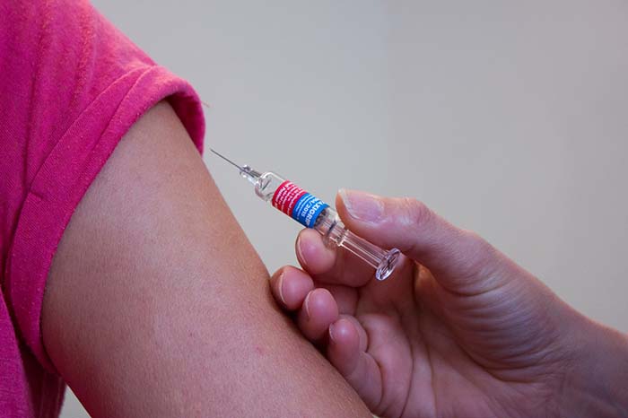 Arm kriegt Impfung verabreicht